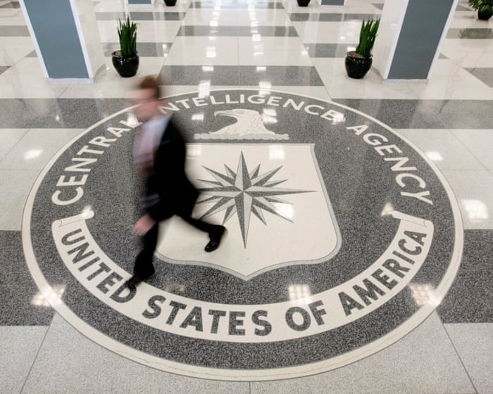A man walks across the Central Intelligence Agency seal set into the agency's lobby floor.