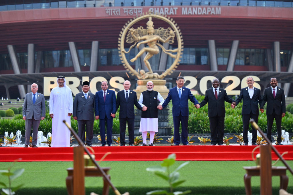 BRICS leaders hold hands for a group photograph at the Bharat Mandapam summit venue.