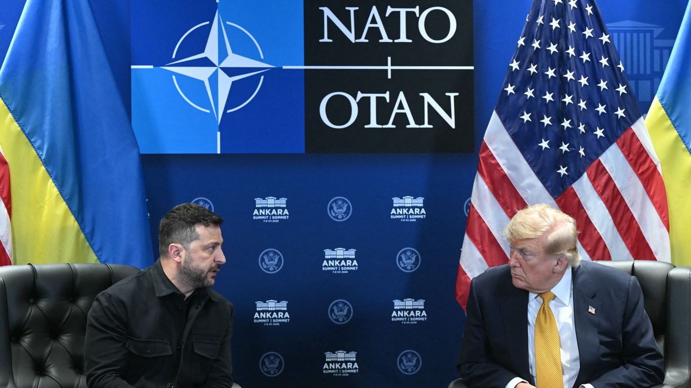 President Zelensky and President Trump sit in adjacent armchairs beneath a NATO logo, between Ukrainian and U.S. flags.