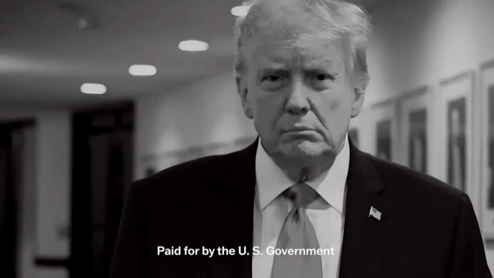 A black-and-white frame from one of the ads: Trump stands in a corridor above the caption “Paid for by the U.S. Government.”