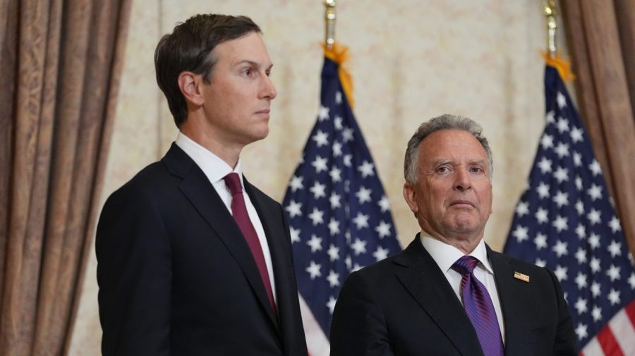 Kushner and Witkoff stand before American flags during an indoor appearance.